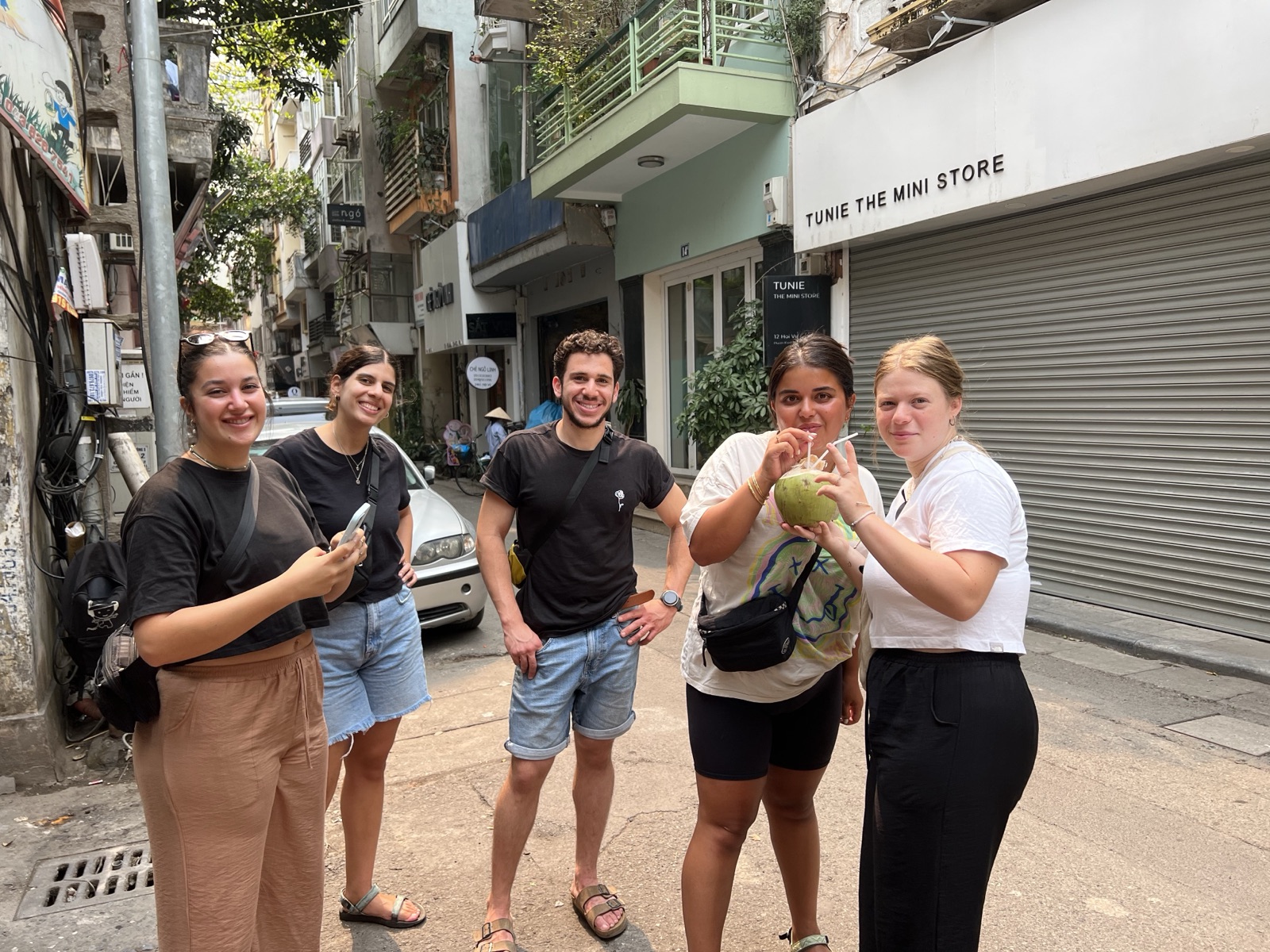 Tour group enjoying fresh coconut in Hanoi